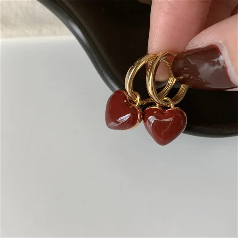 Brincos femininos dourados com detalhe vinho